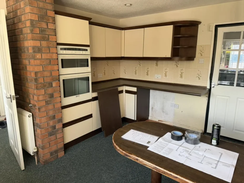 The original dated kitchen in Walton before renovation, with the load-bearing brick pillar that was later removed