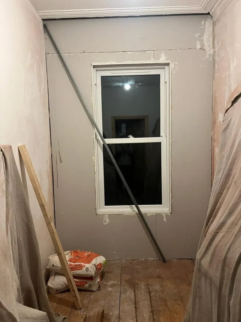 New studded partition wall and window opening plastered out to form the fourth bedroom