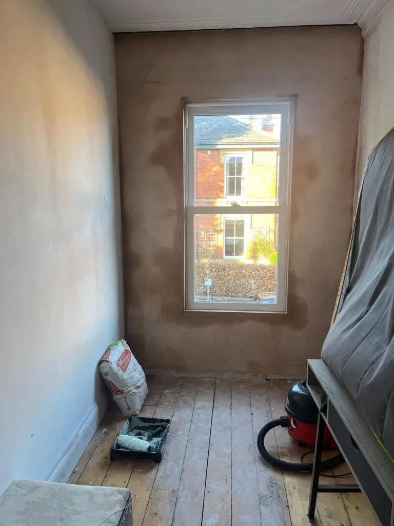 New sash window fitted in the freshly plastered bedroom, seen from inside