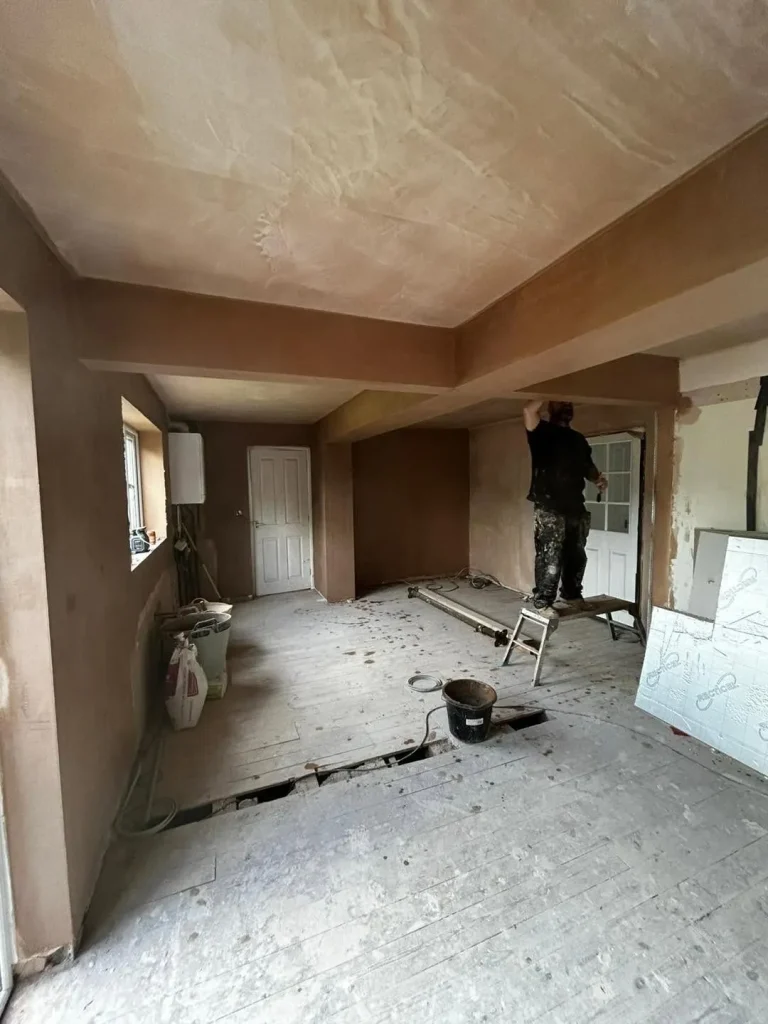 The open-plan kitchen and dining room freshly plastered, with the steels boxed in