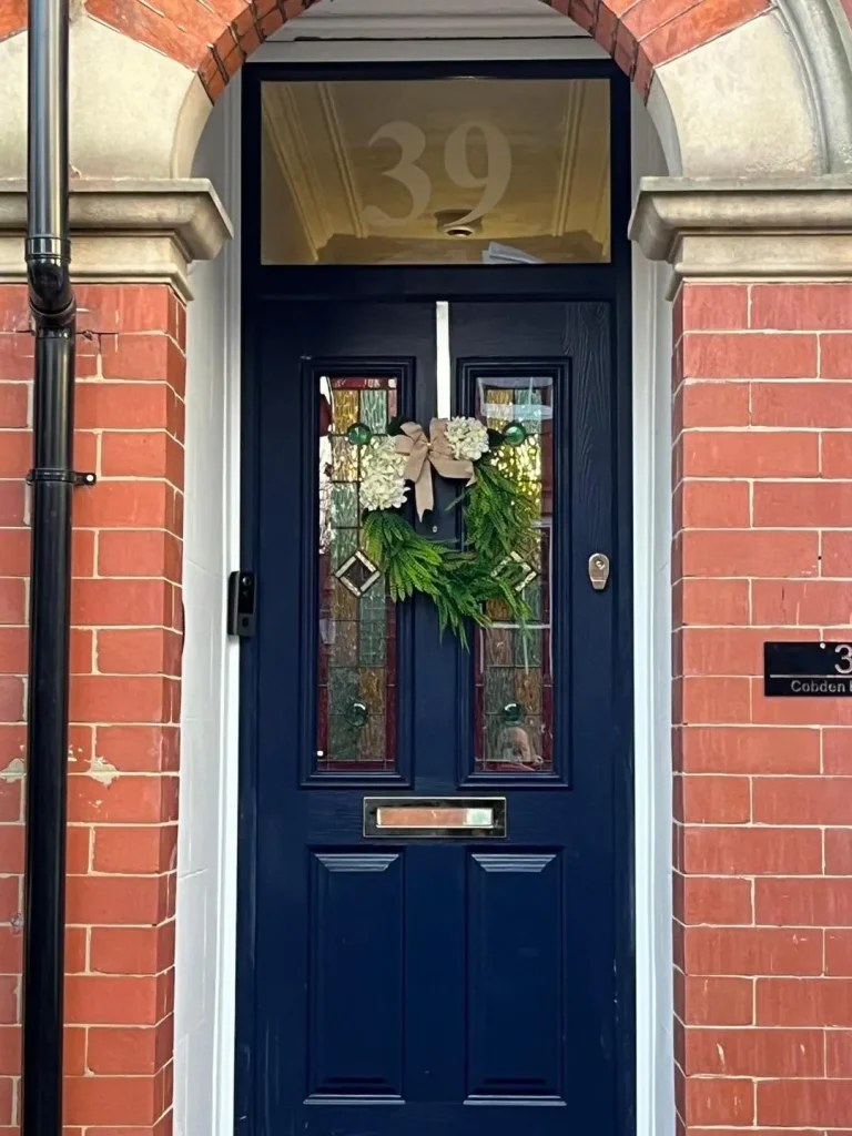 Navy composite front door with a numbered glass panel above, supplied and fitted by GSM Construction