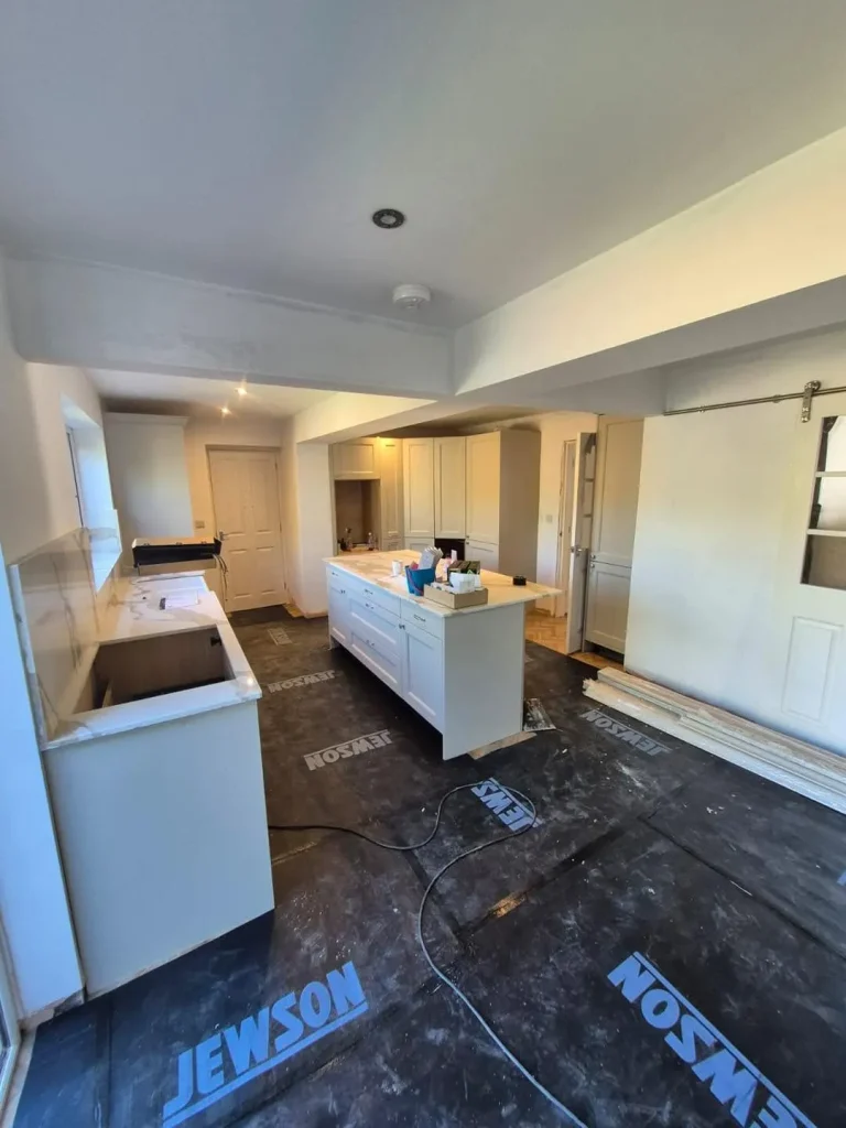The kitchen island and worktops in place with floor protection down