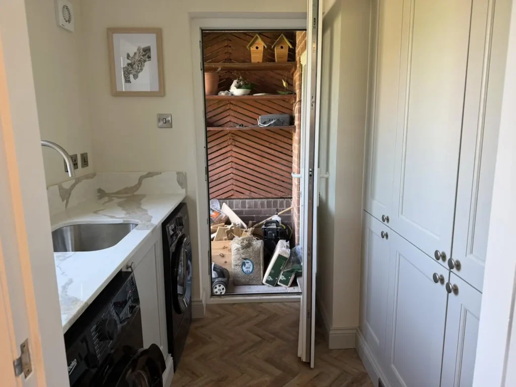 The finished utility room with tall storage units and herringbone LVT